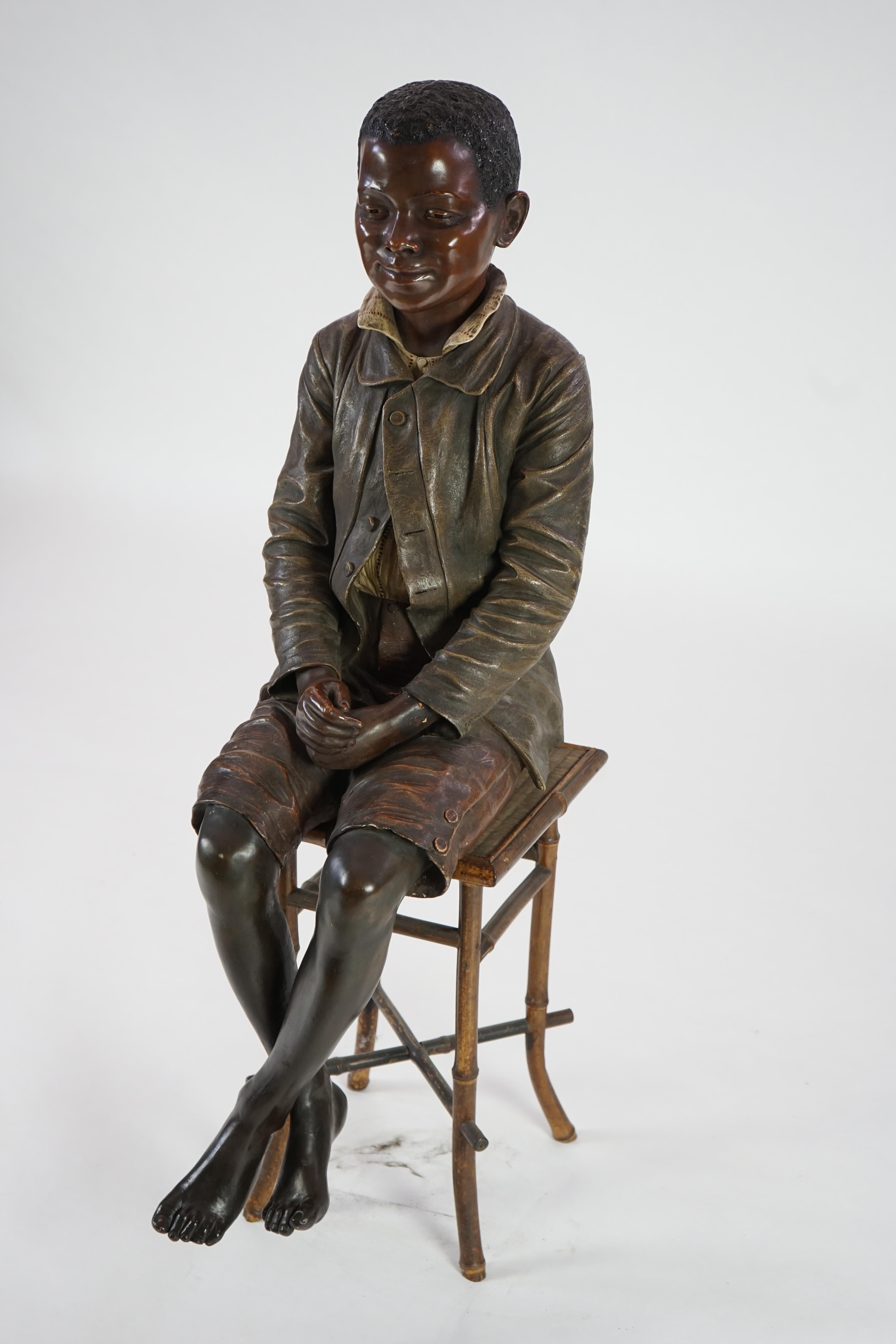 A late 19th century Friedrich Goldscheider life size cold painted terracotta figure of a black boy